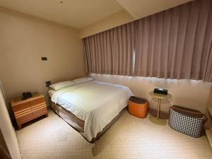 Rúm í herbergi á Rich & Free Hotel - Fuzhong 富逸旅趣-板橋府中館