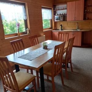 a kitchen with a wooden table and chairs at Apartmány SvoKač in Malá Morávka +2 photos