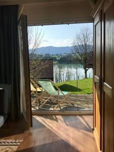 Cette chambre dispose d'une porte coulissante en verre offrant une vue sur le lac. dans l'établissement Ferienhaus Nr 128, Kategorie Komfort Plus L, Feriendorf Hochbergle, Allgäu, à Lechbruck am See