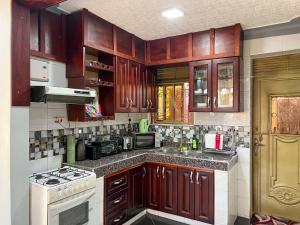 a kitchen with wooden cabinets and a white stove top oven at Benja holiday home in Katale