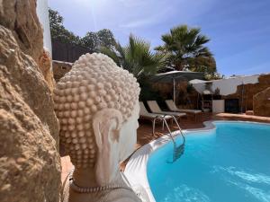 een standbeeld van een hoofd naast een zwembad bij Villa Casa Senna in Corralejo