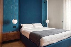 a bedroom with a large bed with blue walls at JOIVY Elegant apartment Zaffiro near Porta Venezia in Milan