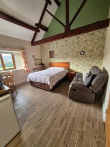 un dormitorio con una cama y un sofá en Padley Farm, en Bradfield