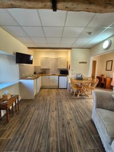 a living room with a couch and a table and a kitchen at Padley Farm in Bradfield
