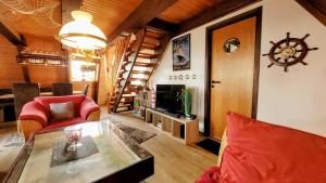 a living room with a table and a television at Ankerplatz Twielenfleth in Twielenfleth