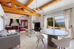 a living room with a table and a couch at Tra Vigna e Mare in Plan-de-la-Tour