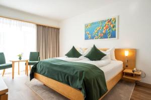 a bedroom with a large bed with a green blanket at Hotel Klinglhuber in Krems an der Donau