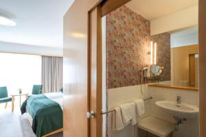 a bathroom with a sink and a bedroom with a bed at Hotel Klinglhuber in Krems an der Donau