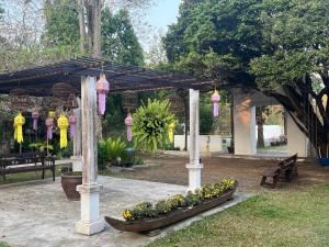 un giardino con panchina e pergolato fiorito di The Puka Boutique Resort a Chiang Mai Altre 4 foto