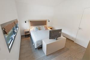 a small bedroom with a bed and a tv at Villa Super VIP | 4 pers. (Villa 68) in Ouddorp