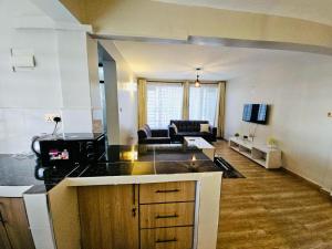 a kitchen and living room with a couch in a room at Treands BnB in Nakuru