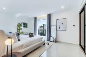 a white living room with a couch and a large window at Luxurious Brand New 2BR Apartment in Rimal 1 I Steps to the JBR Beach I GYL Holiday Homes in Dubai +38 photos