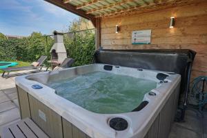 a jacuzzi tub in a backyard with a patio at Oude Nieuwelandseweg 33A - Ouddorp - Villa IJsvogel (with jacuzzi, extra costs for use) in Ouddorp