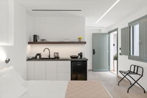 a white kitchen with a sink and a counter at Dream of Paros in Parikia