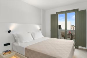 a bedroom with a white bed and a balcony at Dream of Paros in Parikia