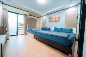 a large blue bed in a room with a window at Luxury Chill Pool Villa in Pattaya Central +14 photos