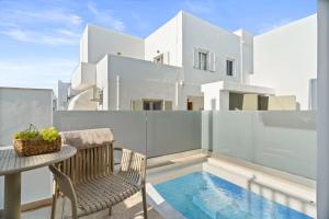 a balcony with a table and chairs and a swimming pool at Dream of Paros in Parikia