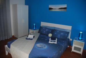 una camera blu con un letto con una parete blu di Eolo a Marsala
