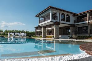 a large swimming pool in front of a house at Boutique Complex Trakiets in Duwanlii