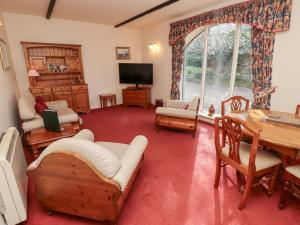 a living room filled with furniture and a large window at Cherryburn Cottage in Wooler