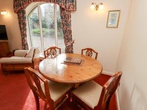 a dining room with a table and chairs and a window at Cherryburn Cottage in Wooler
