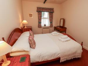 a bedroom with a bed with two towels on it at Cherryburn Cottage in Wooler +42 photos