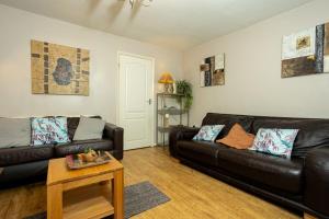 a living room with two leather couches and a table at Cosy 2 Bedroom Home Sleeps 4, Free WiFi, Parking, Central Warwick, West Midlands in Warwick
