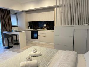 a white kitchen with a bed and a table at Best Value Studio Primavara, Free Parking in Bucharest