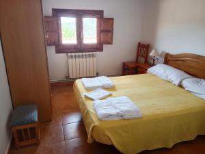 una camera da letto con un letto con asciugamani sopra di El rincón de la abadia a Fuentes de Rubielos