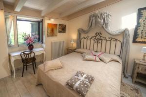 a bedroom with a bed and a desk and a window at Villetta La Foresteria in Verbania