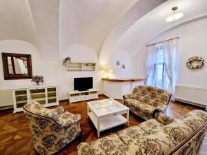 a living room with two couches and a tv at Marina Old Town Apartment with 1 free parking offsite in Košice