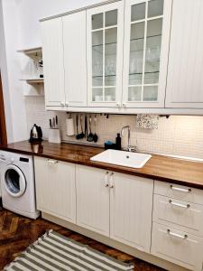 a white kitchen with a sink and a washing machine at Marina Old Town Apartment with 1 free parking offsite in Košice