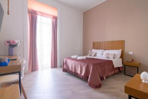 a bedroom with a bed and a desk and a window at Maison do re umberto in Naples