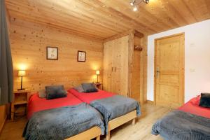 two beds in a room with wooden walls at la levanna in Les Deux Alpes +17 photos