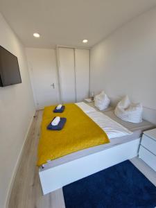 a room with a bed with a yellow blanket at Przytulny Apartament 406 IV piętro in Kołobrzeg
