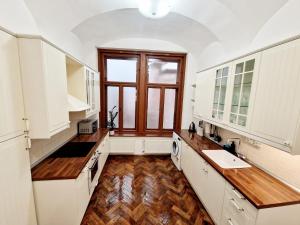 a large kitchen with white cabinets and a window at Marina Old Town Apartment with 1 free parking offsite in Košice +15 photos