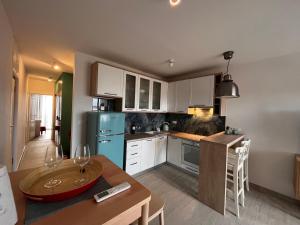 a kitchen with white cabinets and a table with a dining room at Apartment Nona Celina in Zadar +4 photos