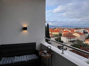 a balcony with a bench and a view of a city at Apartment Nona Celina in Zadar