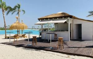 a bar with tables and stools on a beach at Villa Almendro Santa Rosalia Lake and Life Resort by PREMIUM SPAIN PROPERTIES in Torre-Pacheco