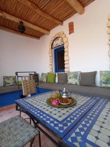 a living room with a table and a couch at Dar Anouar in Sidi Kaouki