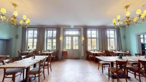 a dining room with tables and chairs and windows at Peter's Resort in Redefin