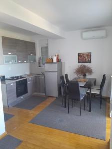 a kitchen and dining room with a table and chairs at Apartman Novalja - Put Lokvice in Novalja