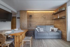 ein Wohnzimmer mit Sofa und Tisch in der Unterkunft Chalet Diamond - AffittiPontediLegno in Ponte di Legno
