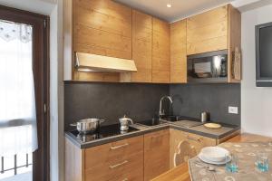 eine Küche mit Holzschränken und einer Spüle in der Unterkunft Chalet Diamond - AffittiPontediLegno in Ponte di Legno