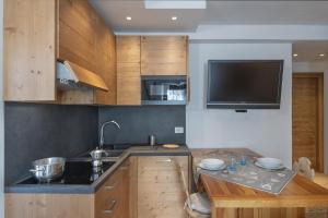 eine Küche mit Spüle und einem Fernseher an der Wand in der Unterkunft Chalet Diamond - AffittiPontediLegno in Ponte di Legno