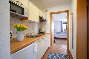 a kitchen with a sink and a vase of flowers at Ferienwohnung Haus am Seeufer Steuerbord in Waren