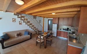 een keuken en woonkamer met een bank en een tafel bij Koxylia apts in Mochlos