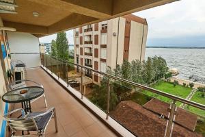 a balcony with a table and chairs and a view of the water at Miraj Apartaments - Exclusive Residence in Mamaia