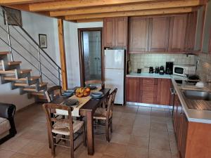 een keuken met een tafel en stoelen en een trap bij Koxylia apts in Mochlos +14 foto's