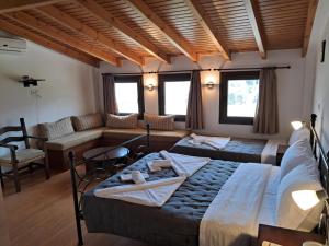 een slaapkamer met twee bedden en een woonkamer bij Koxylia apts in Mochlos